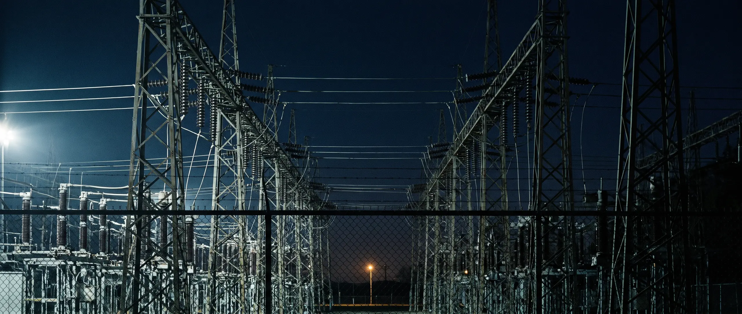 Poste de livraison haute tension à l’heure bleue, pylônes et isolateurs